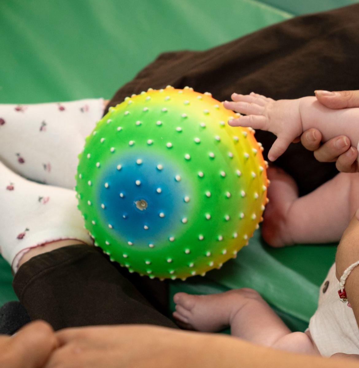 Manos de bebé descubriendo una pelota sensorial