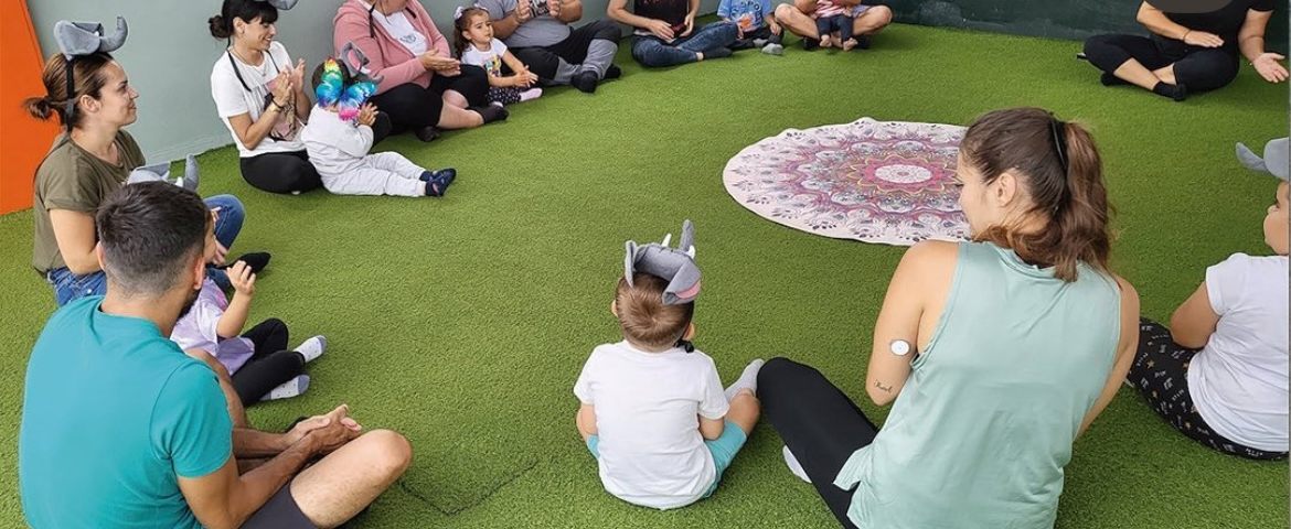 Familias en círculo durante un yogui-cuento